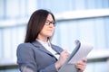 Businesswoman working on digital tablet outdoor over building background