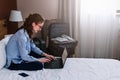 Businesswoman working in hotel room, using laptop and mobile phone Royalty Free Stock Photo