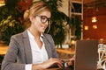 Businesswoman Working On Laptop In Coffee Shop. Young business woman uses laptop in cafe. Royalty Free Stock Photo