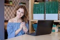 Businesswoman Working On Laptop In Coffee Shop. Young business woman uses laptop in cafe. Businesswoman working typing Royalty Free Stock Photo