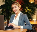 Businesswoman Working On Laptop In Coffee Shop. Young business woman uses laptop in cafe.Lifestyle and business concept. Royalty Free Stock Photo