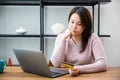 businesswoman working with laptop computer while sitting at table in office she thinking Royalty Free Stock Photo