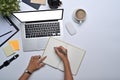 Business woman working with laptop and making notes on notebook. Royalty Free Stock Photo