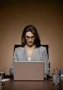 Businesswoman working late and typing on laptop