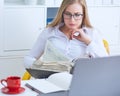 Young beauiful Caucasian businesswoman in glasses working on notebook computer and business document at office.