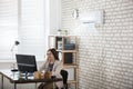 Businesswoman Working In Office With Air Conditioning