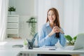 Businesswoman working in the office during coffee break smiling at the window giving a clear vision of work and success instilling