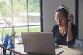 Businesswoman working online at the home office via laptop. Asian young entrepreneurs watching webinars and talking during meeting Royalty Free Stock Photo