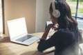 Businesswoman working online at the home office via laptop. Asian young entrepreneurs watching webinars and talking during meeting Royalty Free Stock Photo