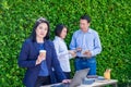 Businesswoman working outside office with team at green leaf wall,business on go and using digital technology device to corporate Royalty Free Stock Photo