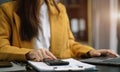 Businesswoman working with smartphone and using a calculator to calculate the numbers of static in office. Finance accounting Royalty Free Stock Photo