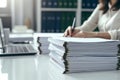 Businesswoman working in stacks of paper files for searching information on work desk in office, business report papers Royalty Free Stock Photo