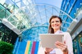 Businesswoman working on tablet against glassy modern office building Royalty Free Stock Photo