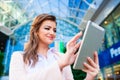 Businesswoman working on tablet against glassy modern office building Royalty Free Stock Photo