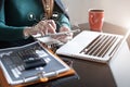 Businesswoman working with tablet and using a calculator to calculate the numbers of static in office. Finance accounting concept Royalty Free Stock Photo