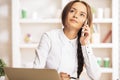 Businesswoman at workplace talking on smartphone Royalty Free Stock Photo