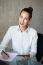 Businesswoman write on blank paper and holding tablet