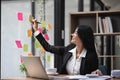 businesswoman write tasks creative ideas and planning on sticky post it note on glass wall.project strategy plan writing Royalty Free Stock Photo