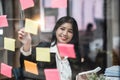 businesswoman write tasks creative ideas and planning on sticky post it note on glass wall.project strategy plan writing Royalty Free Stock Photo