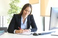 Businesswoman writing in an agenda at office Royalty Free Stock Photo