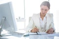 Businesswoman writing on diary on desk Royalty Free Stock Photo