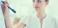 Businesswoman writing on flipchart while giving presentation to colleagues in office Royalty Free Stock Photo