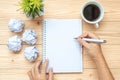 Businesswoman writing with notebook, crumbled paper and black coffee cup on table. New Year Start, Creative, Idea, Resolution, Sol Royalty Free Stock Photo