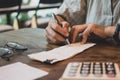 Businesswoman Writing paper and using calculator Calculating bonusOr other compensation to employees to increase productivity. Royalty Free Stock Photo