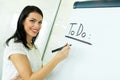 Businesswoman writing todo onto a white writing board