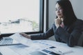 Businesswomen bookkeeper holding graph use calculator and laptop doing account for paying tax on white desk in working office Royalty Free Stock Photo