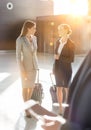 Businesswomen discussing plans while walking with their suitcase in airport