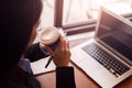 Businesswomen drink hot coffee between working. laptop, calculator and paper on the table Royalty Free Stock Photo