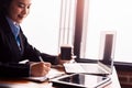 Businesswomen drink hot coffee between working. laptop, calculator and paper on the table Royalty Free Stock Photo