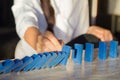 Businesswomen hand Stopping Falling wooden Dominoes effect from continuous toppled or risk Royalty Free Stock Photo