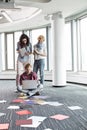 Businesswomen looking at male colleague using laptop on floor in creative office