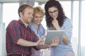 Businesswomen with male colleague using tablet PC in creative office