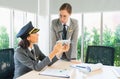 Businesswomen manager and staff of airline wear pilot hat, seriously work, discuss, show airplane model, and look at eye together Royalty Free Stock Photo