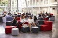 Businesswomen Meeting In Busy Lobby Of Modern Office Royalty Free Stock Photo