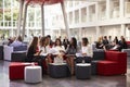 Businesswomen Meeting In Busy Lobby Of Modern Office Royalty Free Stock Photo