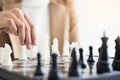 Businesswomen playing chess game makes her move