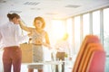 Businesswomen removing tangled cables from box at new office