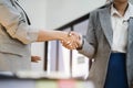 Businesswomen shake hands confidently at an office meeting