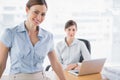 Businesswomen smiling at camera at their desk Royalty Free Stock Photo