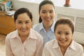 Businesswomen smiling and looking up at camera, in the office Royalty Free Stock Photo