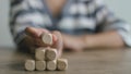 Businesswomen stack blank wooden cubes on the table with copy space, empty wooden cubes for input wording, and an infographic icon