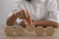 Businesswomen stack blank wooden cubes on the table with copy space, empty wooden cubes for input wording, and an infographic icon Royalty Free Stock Photo