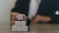 Businesswomen stack blank wooden cubes on the table with copy space, empty wooden cubes for input wording, and an infographic icon