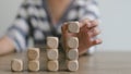 Businesswomen stack blank wooden cubes on the table with copy space, empty wooden cubes for input wording, and an infographic icon Royalty Free Stock Photo