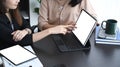 Businesswomen using digital tablet presenting research results of business while discussing.