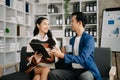 Businesswomen work and discuss their business plans. A Human employee explains and shows her colleague the results paper in modern Royalty Free Stock Photo